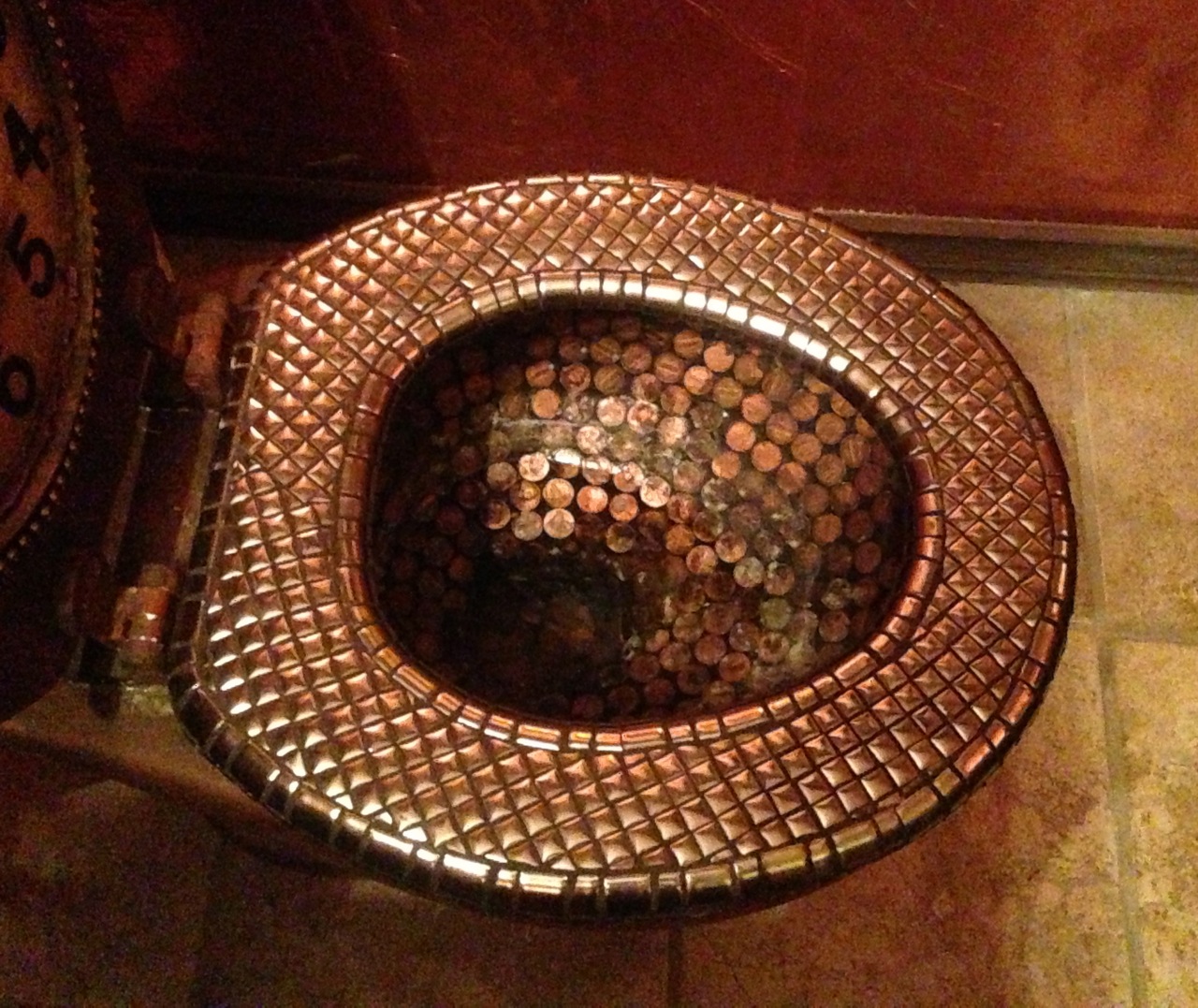 Toilet bowl tiled with copper pennies